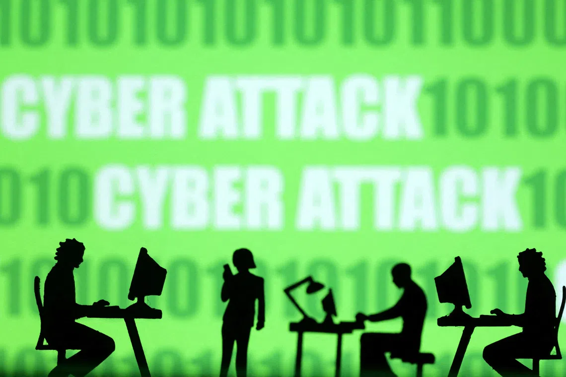 FILE PHOTO: Miniatures of people with computers are seen in front of binary codes and words 'Cyber attack' in this illustration taken July 19, 2023. REUTERS/Dado Ruvic/Illustration/File Photo