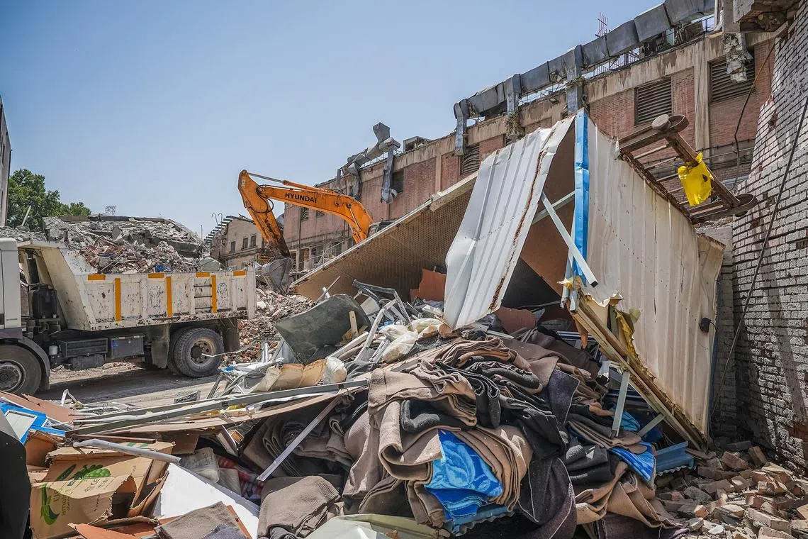 An excavator is used to clear the rubble outside the Evin prison complex on June 25.