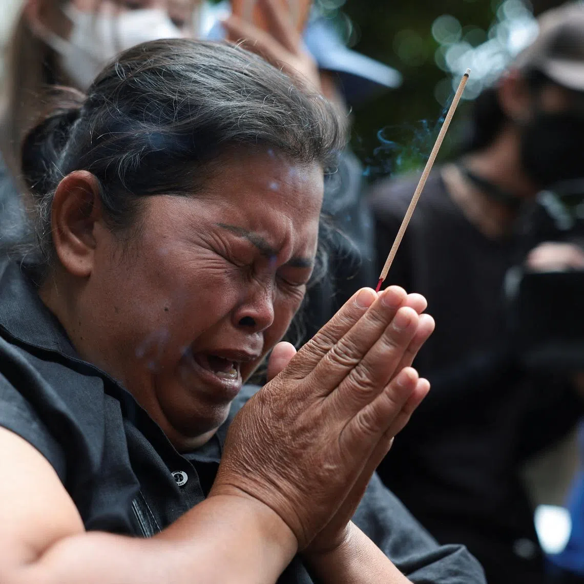 Mother of the victim, Kanokthip Srisuk, visits Rong Beer Na Lat Phrao bar, the site of a deadly fire, to pay tribute to Srisuk and other victims who lost their lives in the bar fire, the day after the incident, in Bangkok, Thailand, July 14, 2026. REUTERS/Chalinee Thirasupa