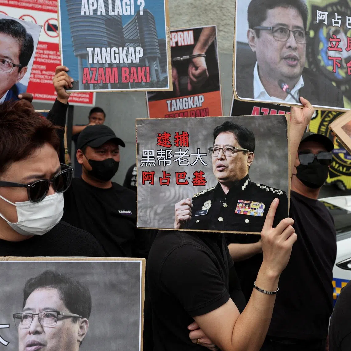 People hold placards bearing images of Azam Baki, chief commissioner of the Malaysian Anti-Corruption Commission (MACC), during a protest calling for his resignation outside the agency’s headquarters at Putrajaya, Malaysia, February 27, 2026. REUTERS/Hasnoor Hussain