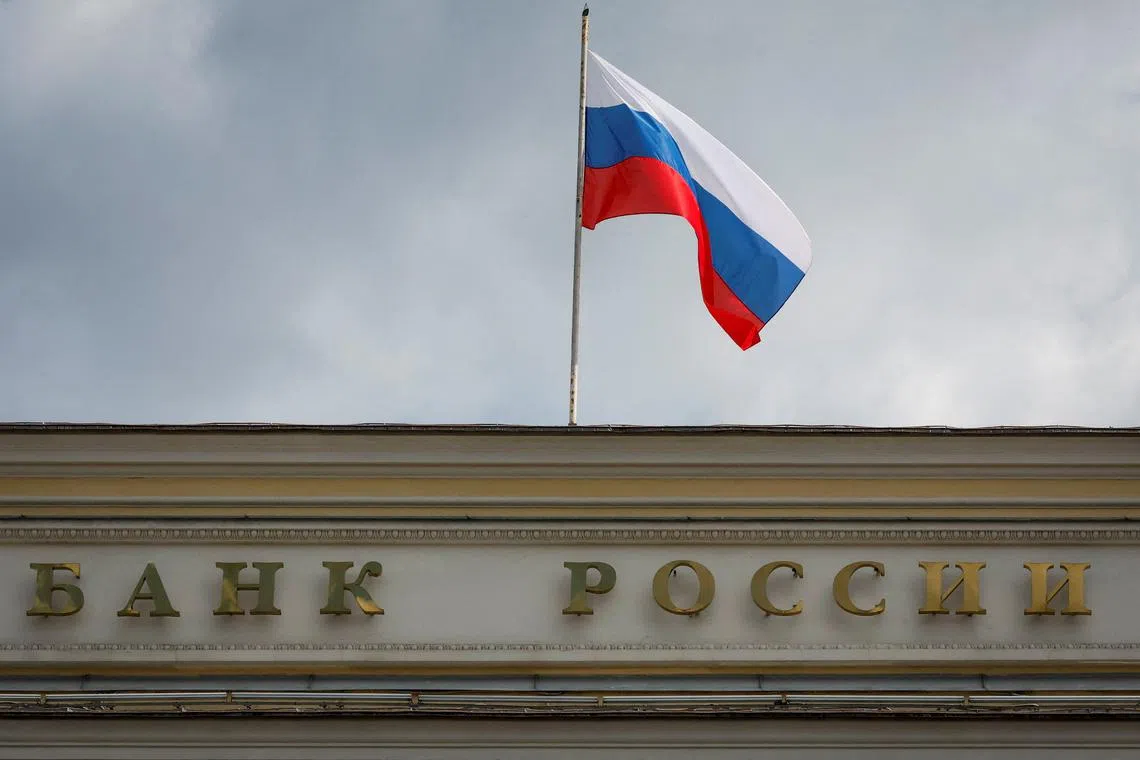FILE PHOTO: A Russian state flag flies over the Central Bank headquarters in Moscow, Russia, August 15, 2023. A sign reads: \"Bank of Russia\". REUTERS/Shamil Zhumatov/File Photo