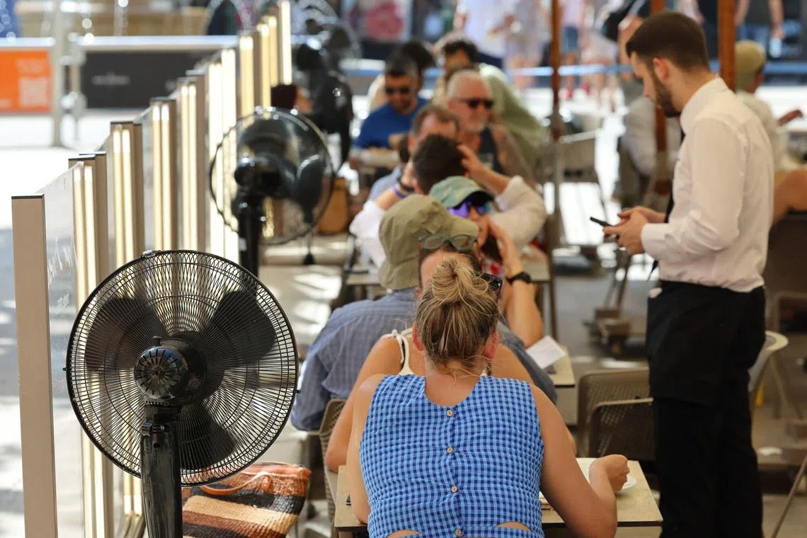 Customers sit near fans at an outdoor restaurant during a heatwave in Palma de Mallorca, Spain, on July 25.