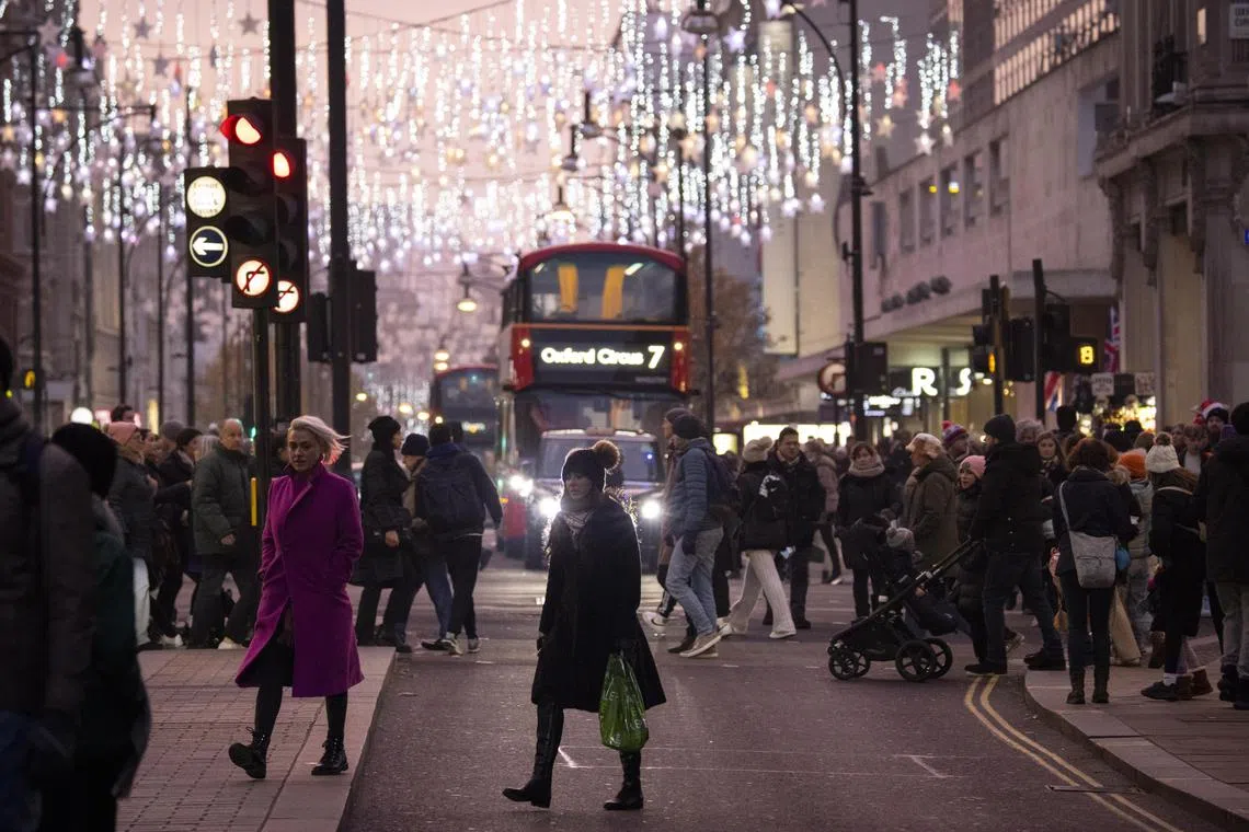 epa10361309 People walk along Oxford Street as they do their Christmas shopping and enjoy the decorations in London, Britain, 11 December 2022.  EPA-EFE/TOLGA AKMEN