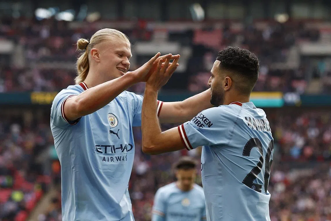 Manchester City's Riyad Mahrez celebrates scoring their second goal with teammate Erling Haaland.