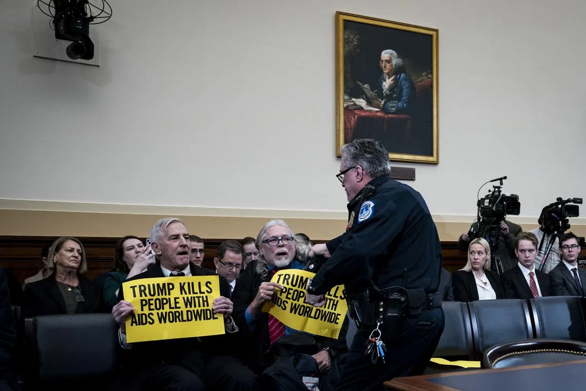 Demonstrators disrupt a House Committee on Foreign Affairs hearing on the funding freeze.