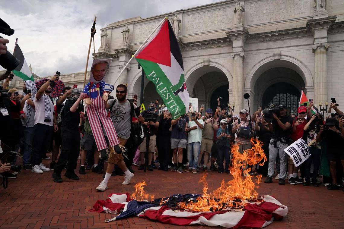 Pro-Palestinian protesters burning a US flag and holding an effigy of Israeli Prime Minister Benjamin Netanyahu outside Union Station, in Washington, on July 24.