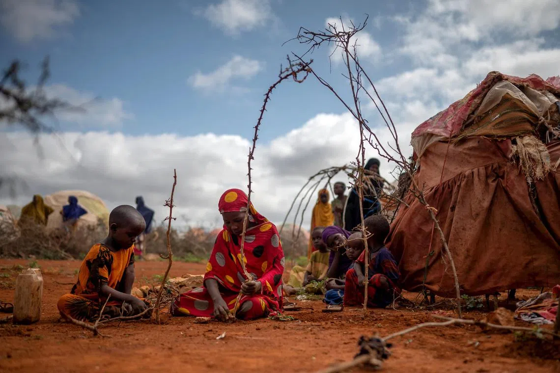 FILE — A girl and her niece build a tent from sticks and rags on the edge of Baidoa, where tens of thousands of people fled to amid the country’s fiercest drought in 40 years, in southern Somalia, on Nov. 3, 2022. Heads of state from across Africa issued a statement at a climate summit on Sept. 6, 2023, that the world’s industrialized countries must  unlock access to their wealth through investments, instead of relegating their contributions to aid when disasters strike. (Andrea Bruce/The New York Times)