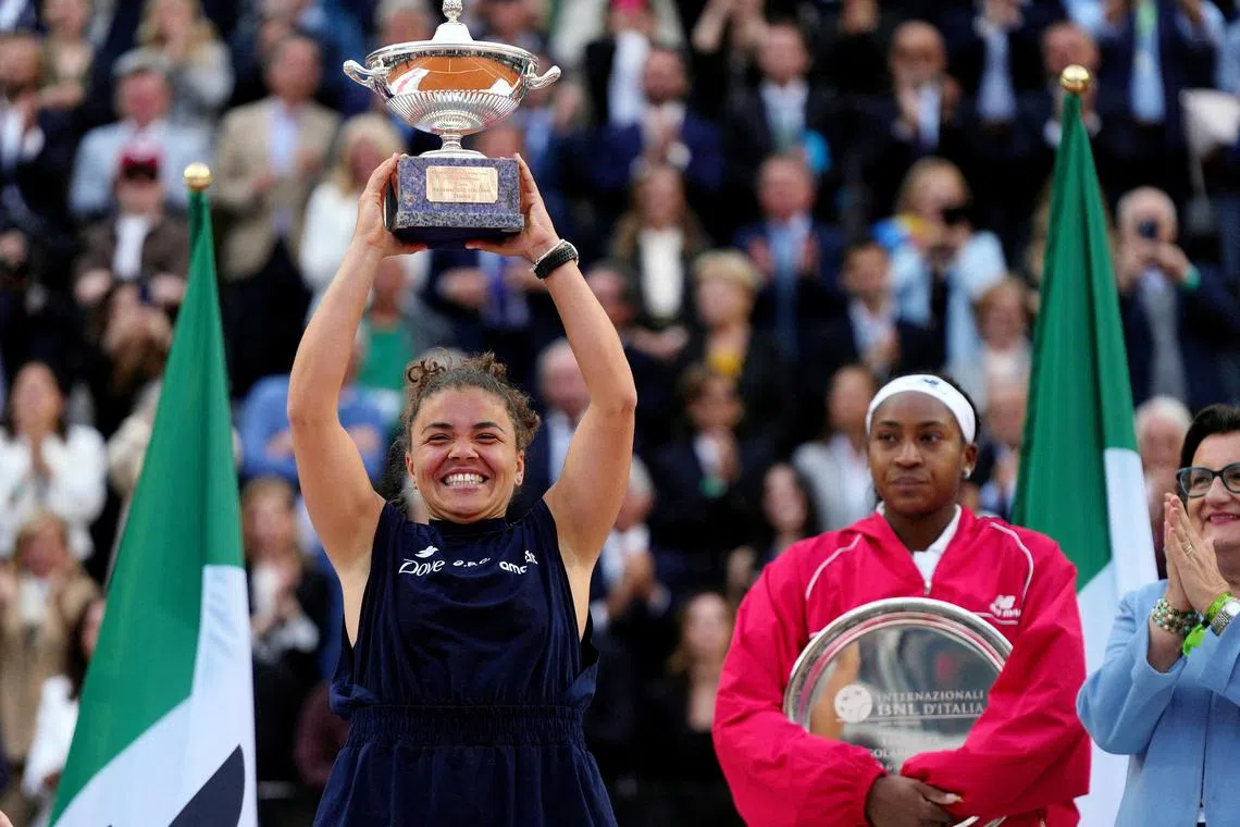 Italy's Jasmine Paolini celebrating with the trophy after winning the Italian Open women's singles final as Coco Gauff of the United States poses with the runners-up trophy at Foro Italico in Rome on May 17.