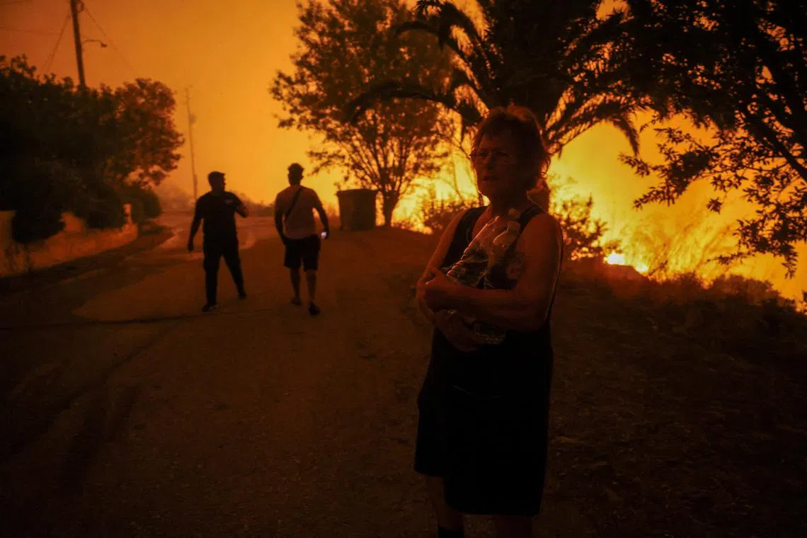 A wildfire burning in the village of Latas, in southern Greece, on June 21.