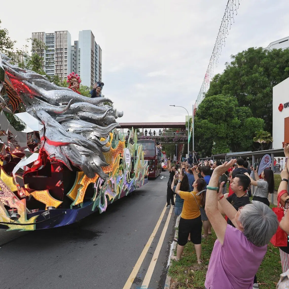 Residents waving as the Chingay Parade 2026 floats embark on a tour around Sembawang on Mar 15, 2026.