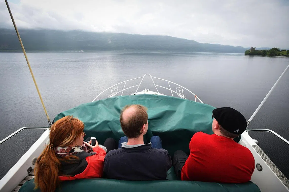 Tourists take a cruise aboard the Nessie Hunter boat on Loch Ness in the Scottish Highlands.