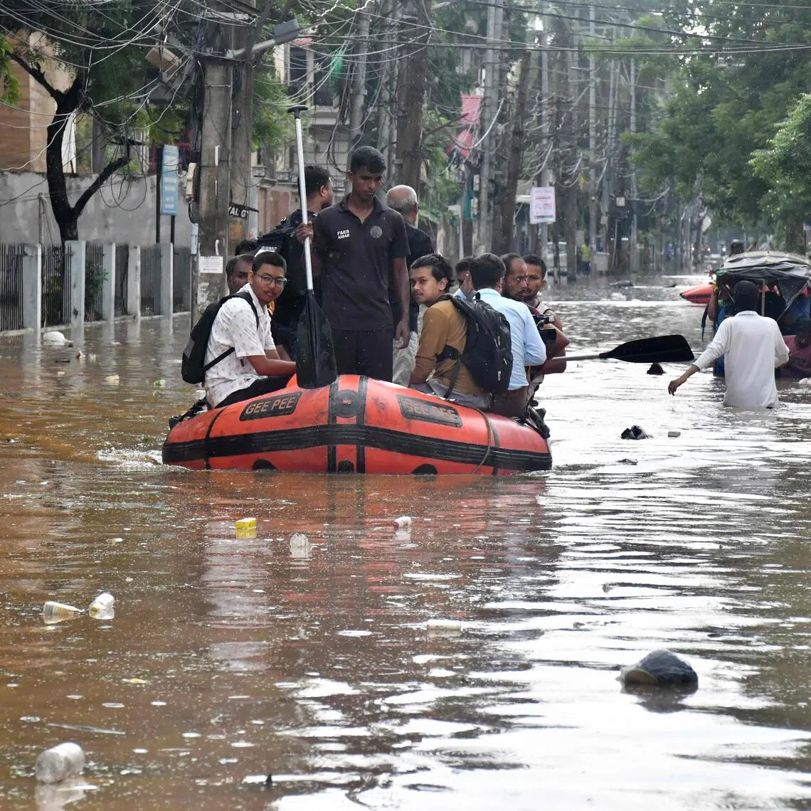 Residents use rafts and inflated boats to reach higher ground with the help of disaster response officials.