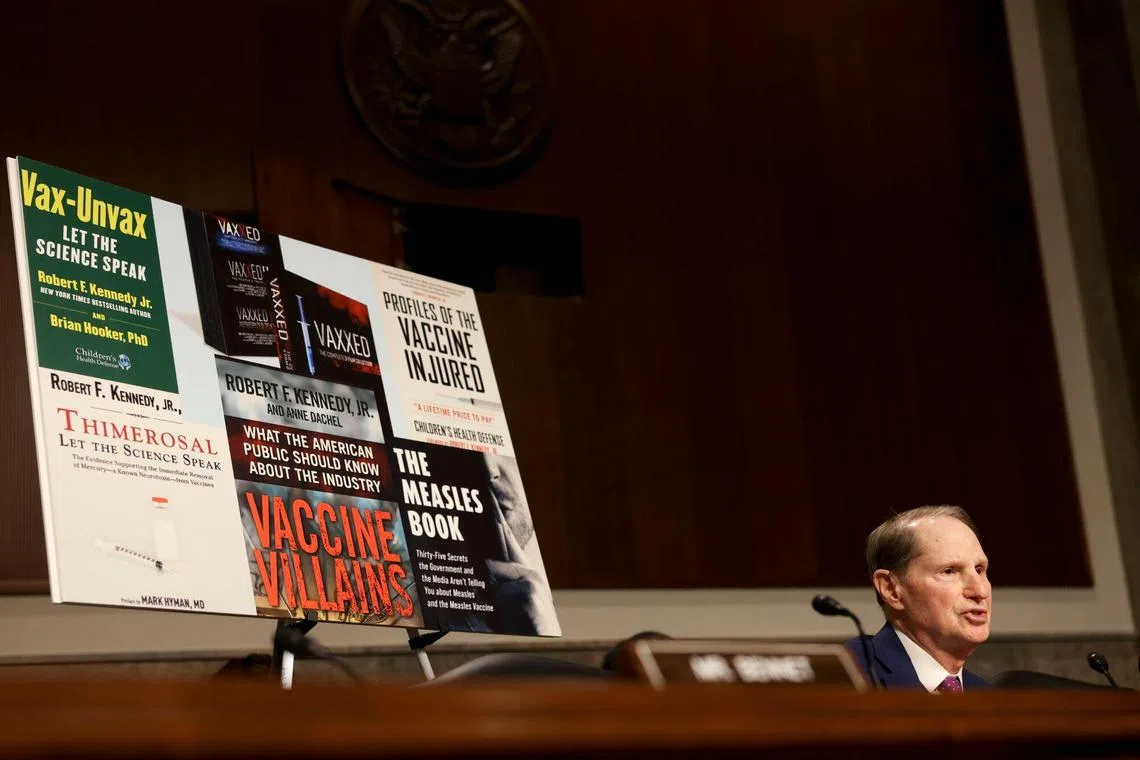 Vaccine signage behind Democrat Senator Ron Wyden during a confirmation hearing for President Donald Trump’s nominee for health secretary.