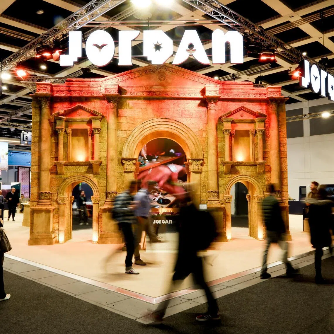 Visitors pass by the Jordan booth at the International Travel Trade Show 2026 (ITB) in Berlin.