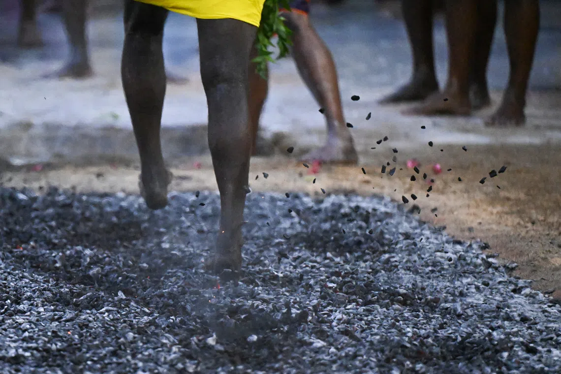 Devotees crossing the fire pit at Sri Mariamman Temple during the annual fire walking festival on Oct 12. 