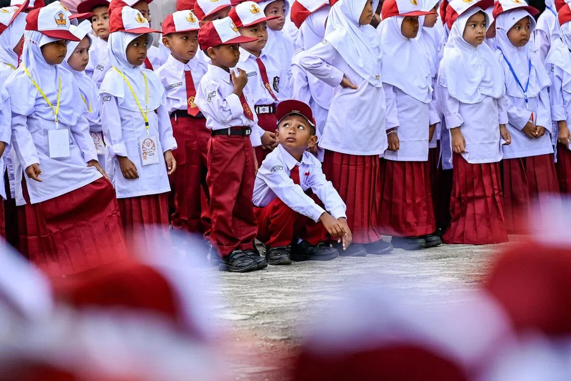 New students take part in a ceremony on the first day of elementary school in Darul Imarah on outskirts of the Banda Aceh on July 13.