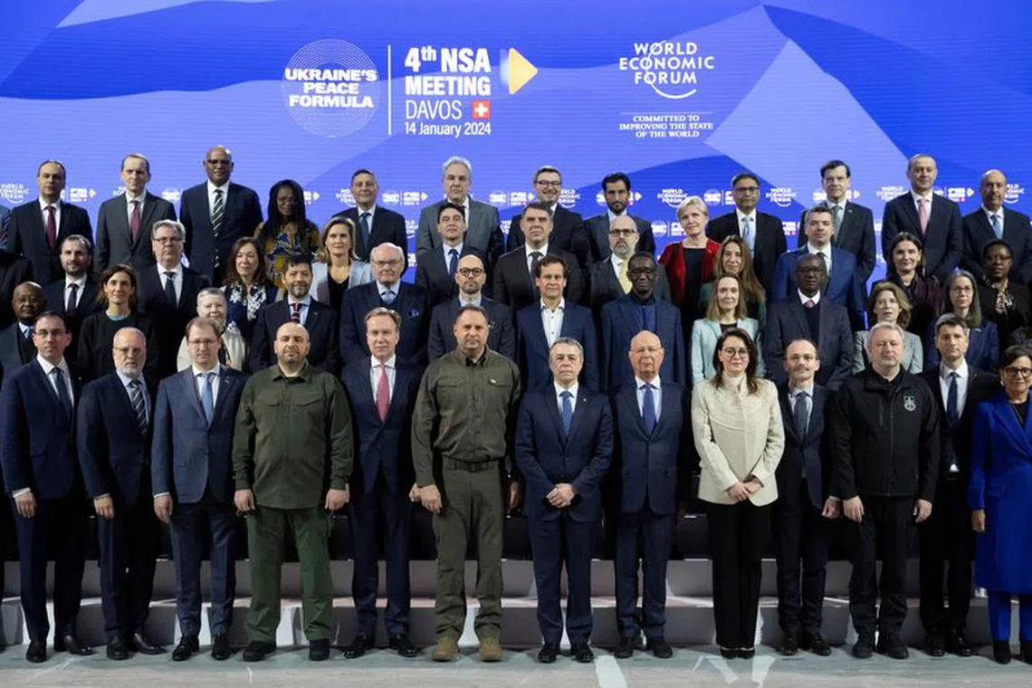 Participants pose for a group picture, with Borge Brende, president WEF, Andriy Yermak, Head of the Ukrainian President's Office, Swiss Federal Councillor Ignazio Cassis, Klaus Schwab, founder WEF, and Yulia Svyrydenko, first deputy prime minister of the Ukraine in the front row, during the 4th meeting of the National Security Advisors (NSA) on the peace formula for Ukraine, in Davos, Switzerland, Sunday, January 14, 2024. The NSA meeting takes place in the Congress Centre, venue for the World Economic Forum (WEF).    GIAN EHRENZELLER/Pool via REUTERS