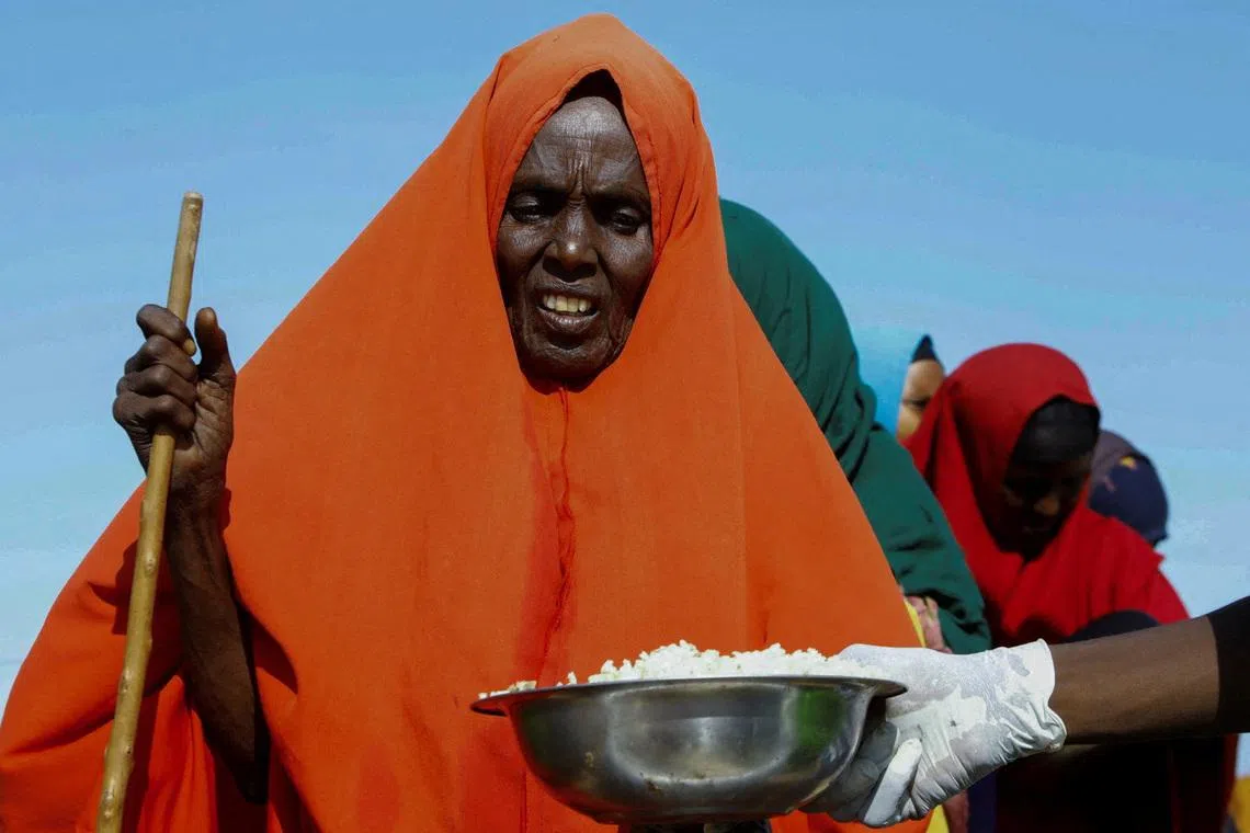 An internally displaced Somali woman receives food rations in the outskirt of Mogadishu, Somalia, March 20, 2024 REUTERS/Feisal Omar/File Photo