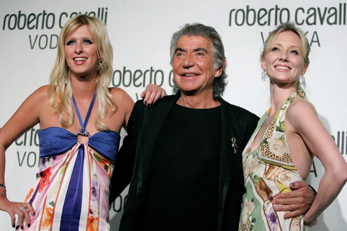 A 2006 photo shows Italian fashion designer Roberto Cavalli posing with Nicky Hilton (left) and actress Anne Heche.