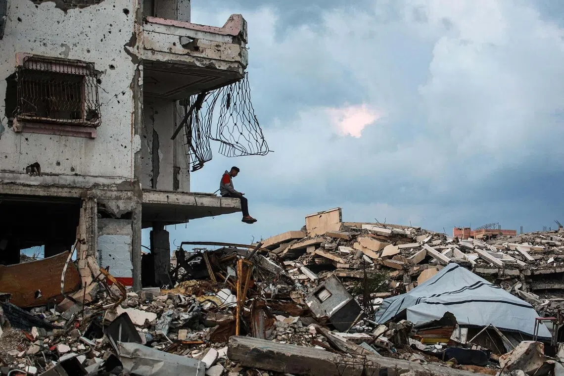 A man sitting on the edge a destroyed building in the Al-Saftawi neighborhood, west of Jabalia city in the northern Gaza Strip on Dec 10, 2025. 