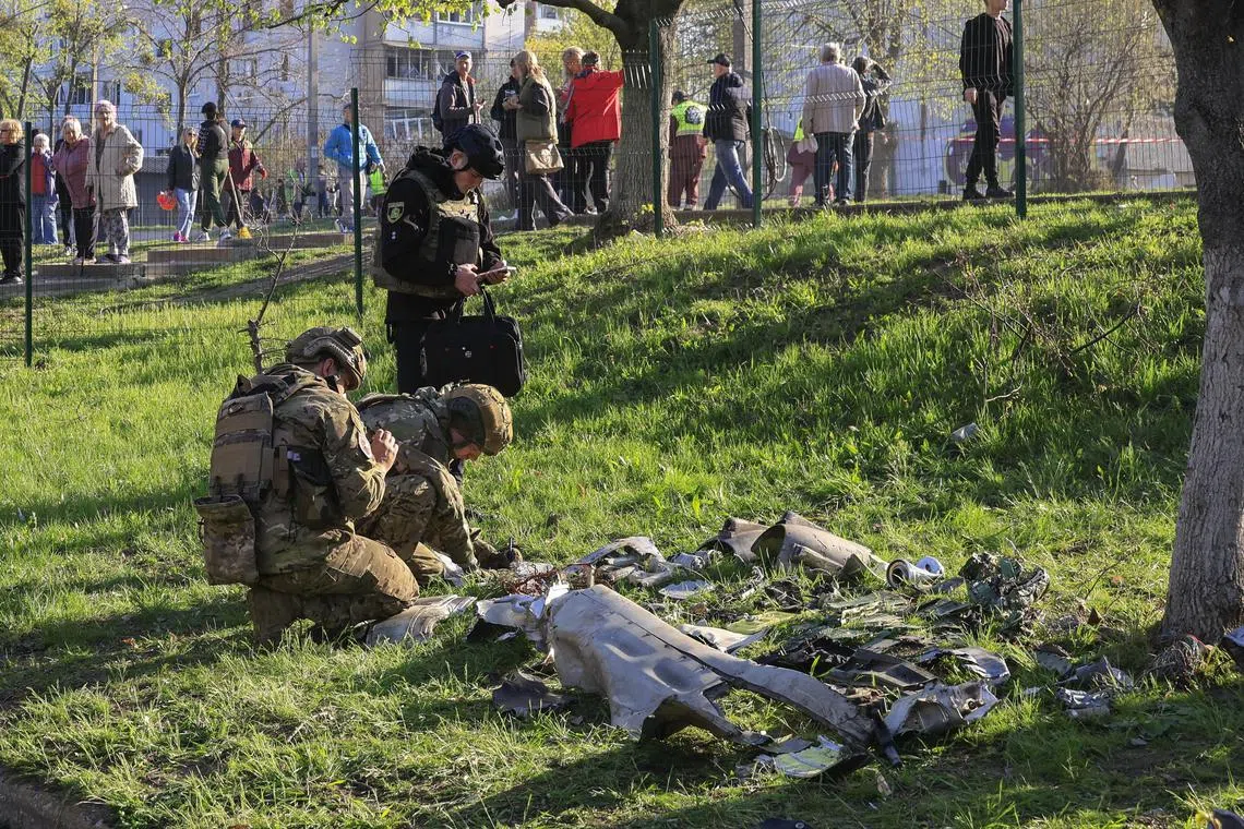 Ukrainian soldiers inspecting debris of a rocket at a residential area that was targeted in Kharkiv, Ukraine, on April 18. 