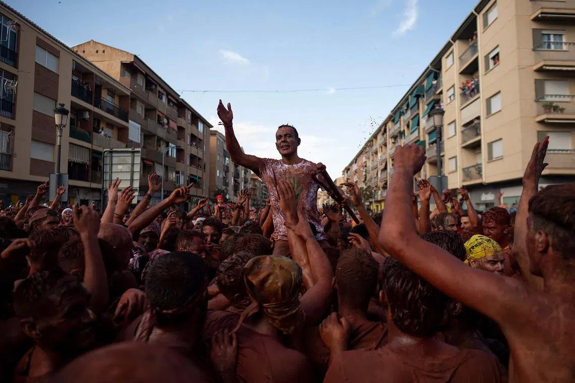 The "Cascamorras" David Marcos Ramirez is carried on shoulders as revellers splashed with different coloured paint participate in the traditional festivities of the Cascamorras, in Guadix, Spain, on Sept 9.