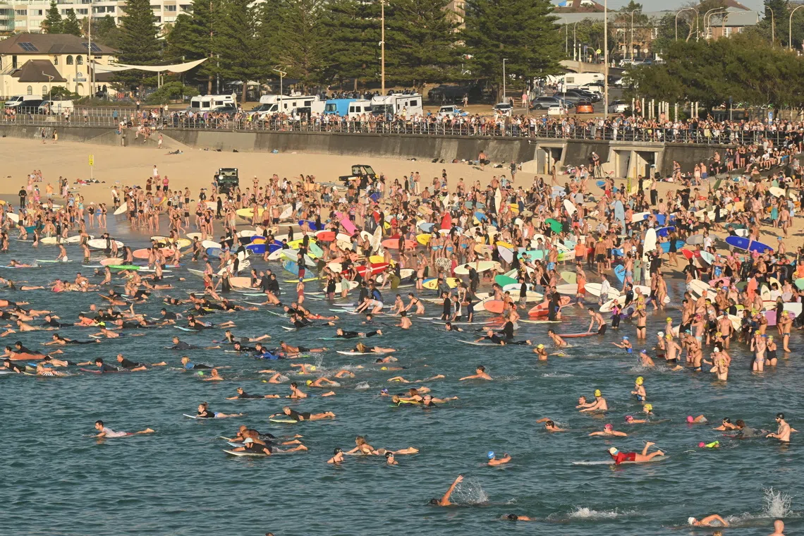 Surfers and swimmers gather for a paddle out to form a ring as a tribute at Bondi Beach on Dec 19.