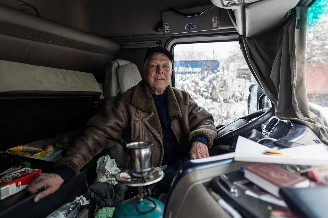 Ukrainian truck driver Igor, 68, is seen in the cockpit of his truck with a lit gas cylinder, on the Polish-Ukrainian border, amid a blockade by Polish truckers.