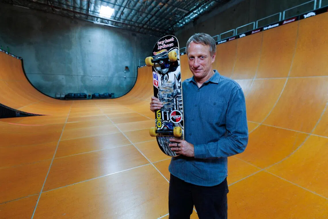 Tony Hawk holds the skateboard he used to land the first-ever "900" at the 1999 X Games, a milestone that transformed skateboarding from subculture to global sport and made Hawk its defining icon.