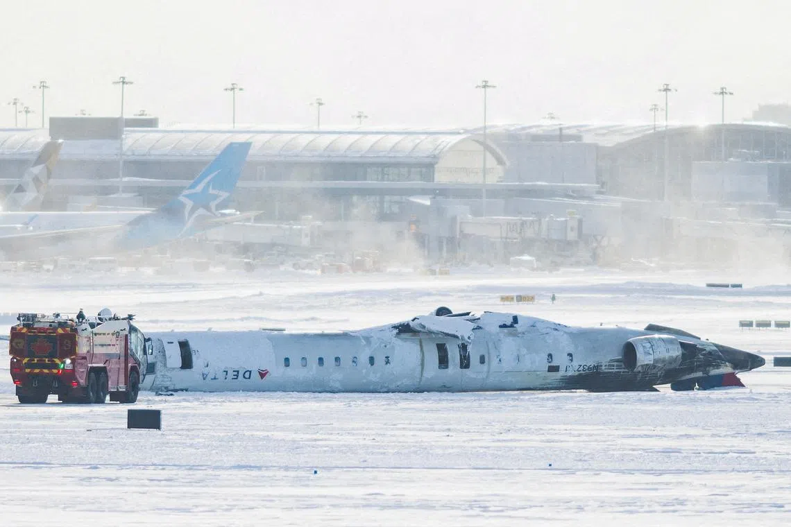 The wreckage of a Delta Air Lines-operated CRJ900 aircraft lying on the runway after a plane crash at Toronto Pearson International Airport, in Mississauga, Ontario, Canada Feb 18, 2025. 