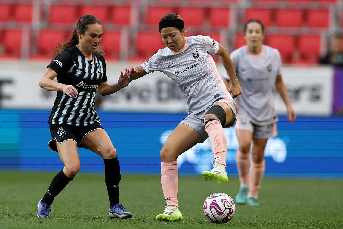 Meleana Shim of the NJ/NY Gotham trying to dispossess Japan winger Jun Endo (right) of Angel City during a match at Red Bull Arena on July 2 in New Jersey.