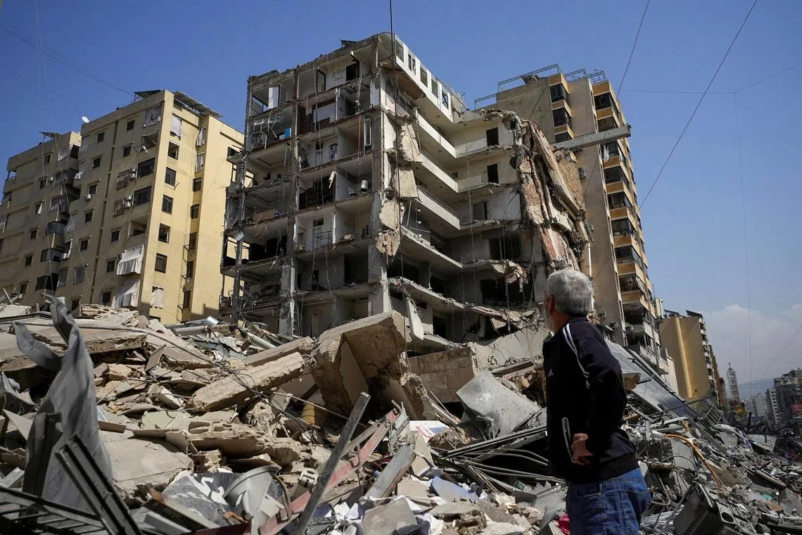 FILE PHOTO: A man stands next to a damaged building in the aftermath of Israeli strikes, amid an escalation between Hezbollah and Israel, amid the U.S.-Israeli conflict with Iran, in Beirut's southern suburbs, Lebanon, March 12, 2026. REUTERS/Stringer/File Photo