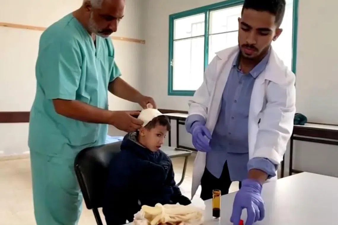 Doctors attend to a patient at a field clinic inside a central Gaza school in Deir Al-Balah, in this screengrab taken from a video on December 22, 2023 . (REUTERS)