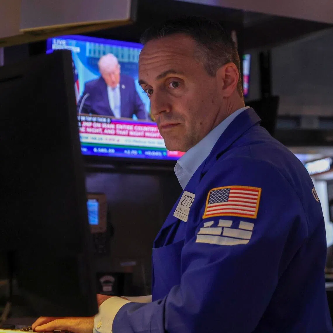 A trader working on the floor of the New York Stock Exchange, as a screen shows US President Donald Trump speaking at a White House press conference on the Iran war on April 6.