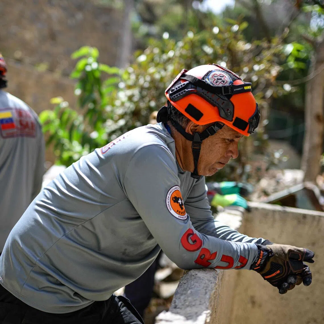 Domingo Pacheco (right) observing collapsed structures during inspection operations in Catia La Mar, Venezuela, on Aug 4.