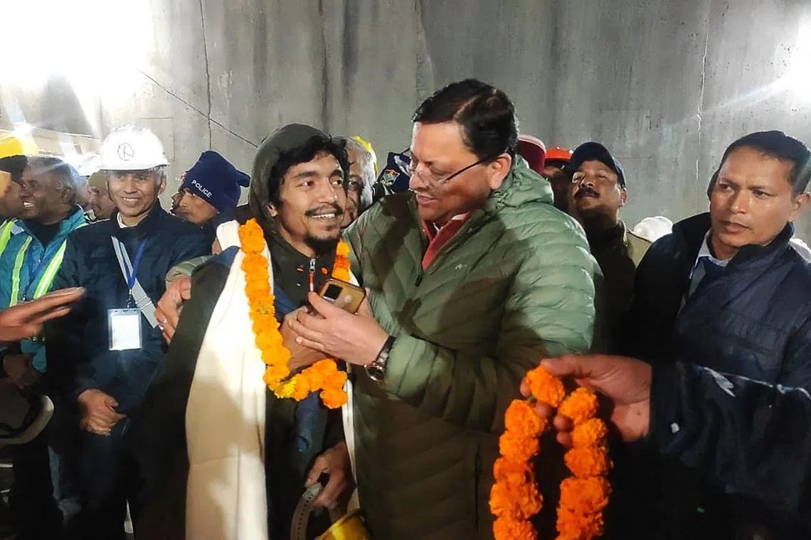 Uttarakhand chief minister Pushkar Singh Dhami (right) embraces a construction worker following his rescue from the collapsed tunnel.