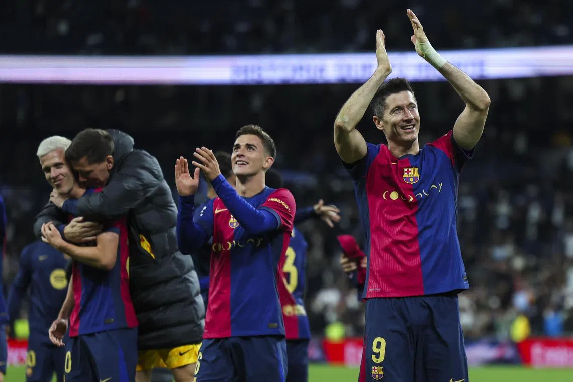 Barcelona's Robert Lewandowski (right) and teammates celebrate with supporters after winning the Spanish LaLiga match against Real Madrid.