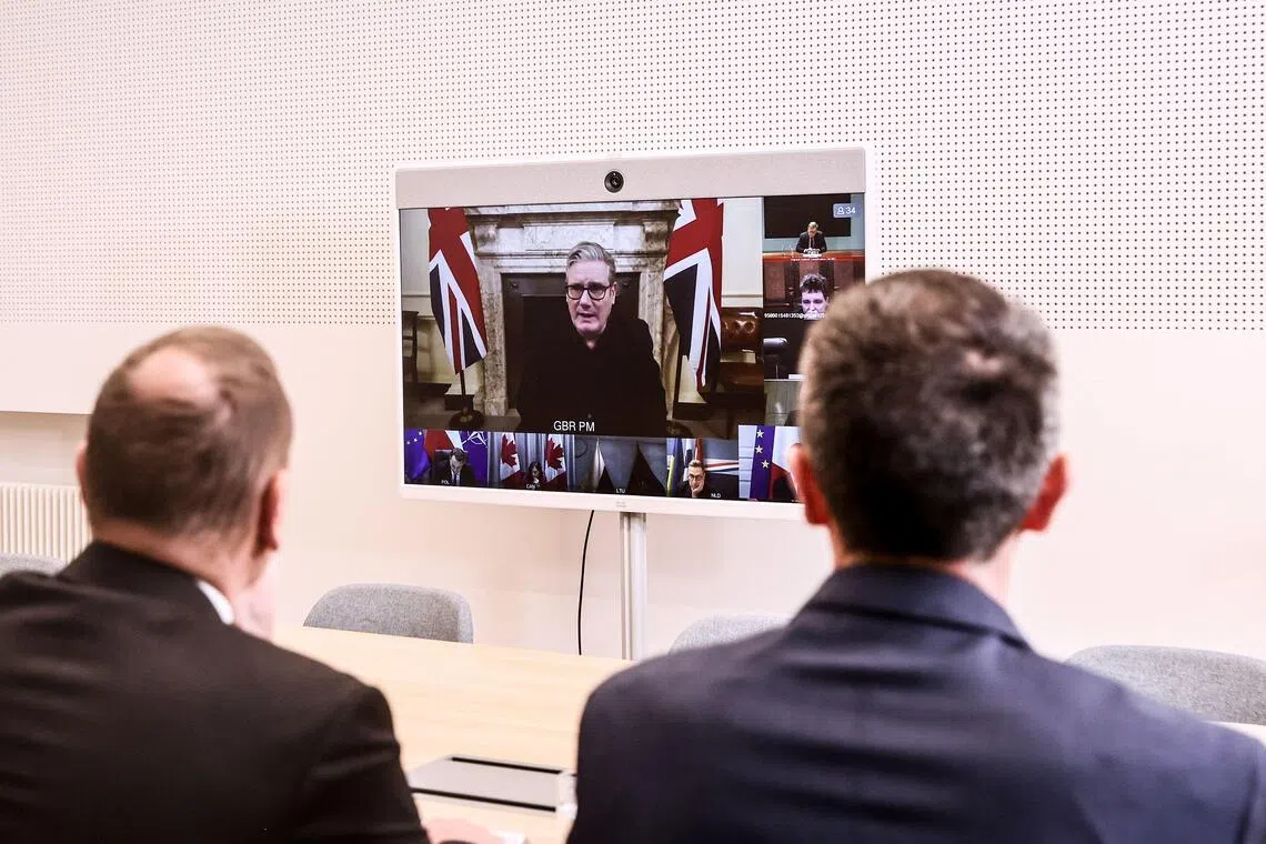 British Prime Minister Keir Starmer (centre) appears on screen at the Elysee Palace in Paris, during a Dec 11 video conference of the Coalition of the Willing.