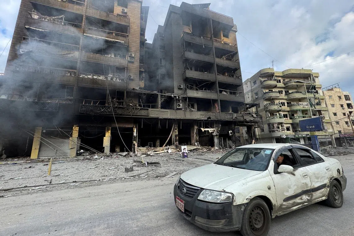 A car drives past burned buildings after an Israeli strike on Beirut's southern suburbs, following an escalation between Hezbollah and Israel amid the U.S.-Israeli conflict with Iran, Lebanon, March 7, 2026. Picture taken with a mobile phone. REUTERS/Stringer