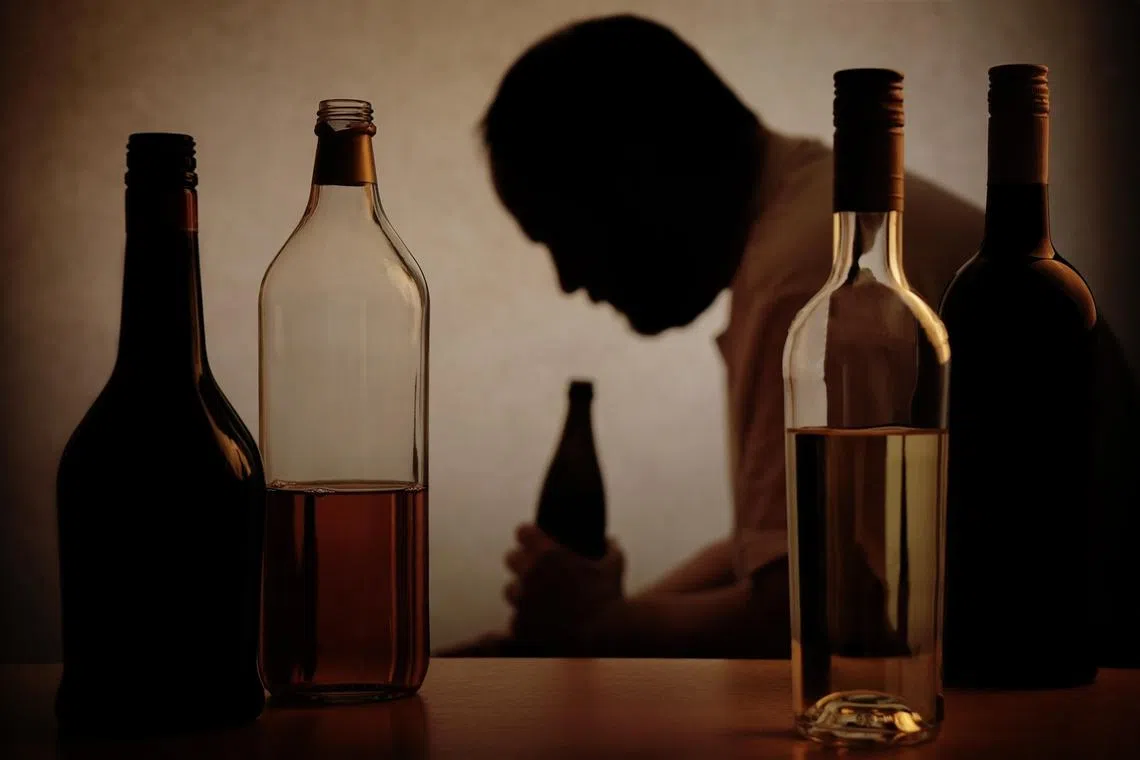 akalcohol16 - Istockphoto - silhouette of a person drinking behind bottles of alcohol with added filter
