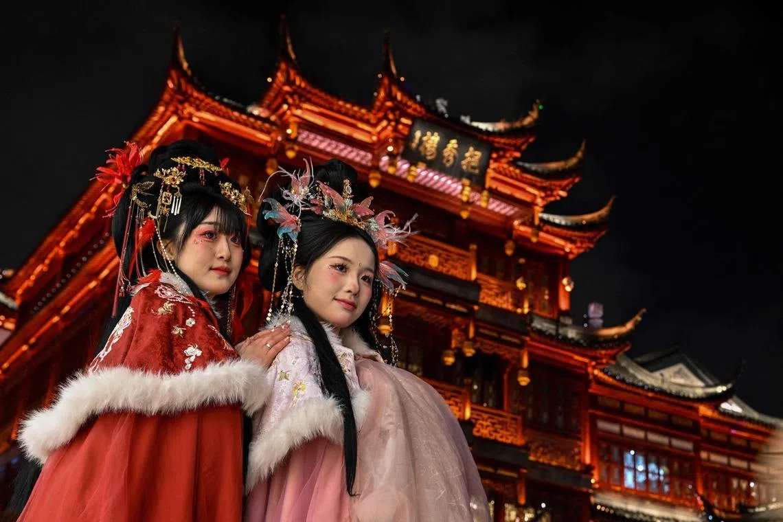 Women in traditional costumes posing for photographs at Yu Garden in Shanghai, China on Jan 21, 2026. 