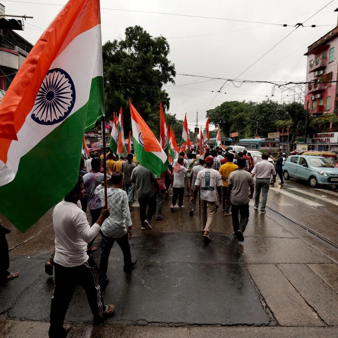 Indians hold national flags as they participate in a tricolor flag march or 'Tiranga Yatra' organised by Bharatiya Janata Party (BJP) in Kolkata, India, on Aug 13.