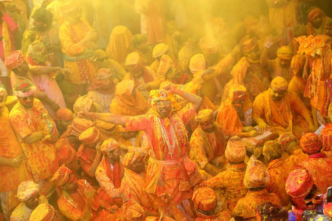 Devotees smear with colours as they celebrate Hindu spring festival of Holi at Shreeji temple in Barsana, Mathura district on Feb 27, 2023.