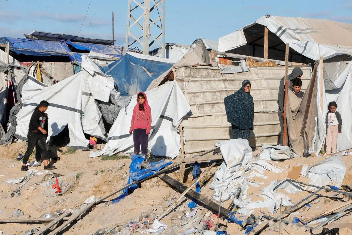 Palestinians inspect the damage at the scene where an Israeli strike killed Hamas political leader Salah al-Bardaweel and his wife in their tent shelter, in Khan Younis in the southern Gaza Strip on March 23.