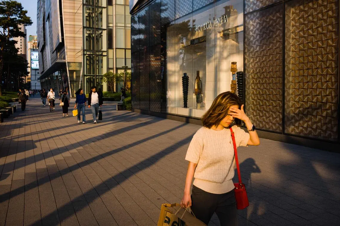 A woman walking past shops at the Gangnam district in Seoul.