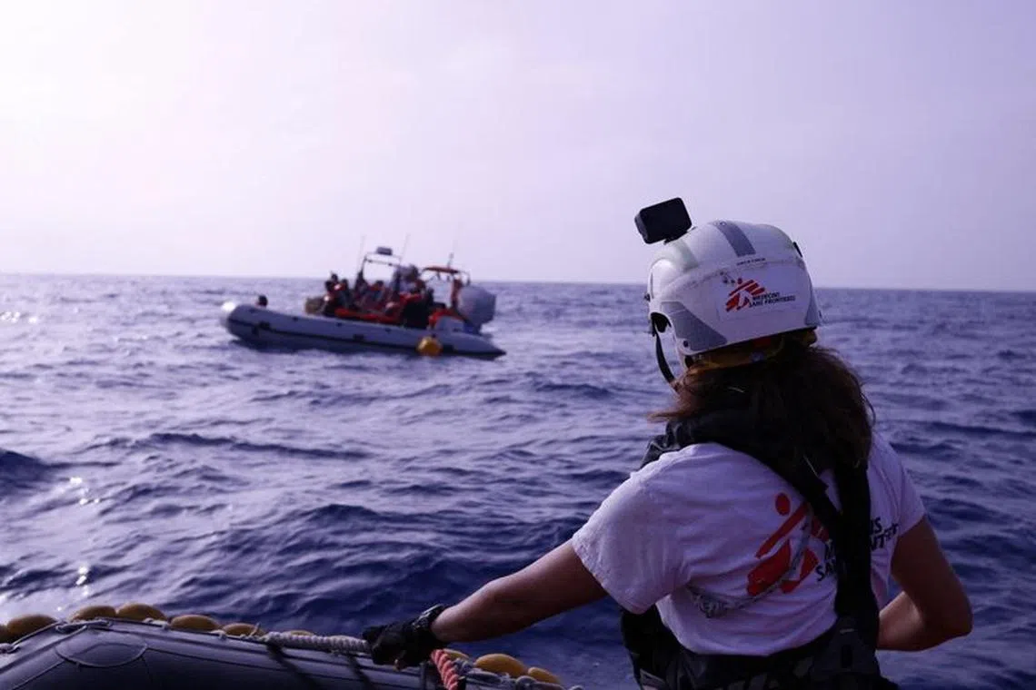 Handout image obtained by Reuters, October 12, 2023 shows a Medecins Sans Frontieres (MSF) rescue boat near a rubber boat carrying migrants from the Middle East and Africa, in Mediterranean Sea, June 24, 2023. MSF/Skye McKee/Handout via REUTERS/File Photo