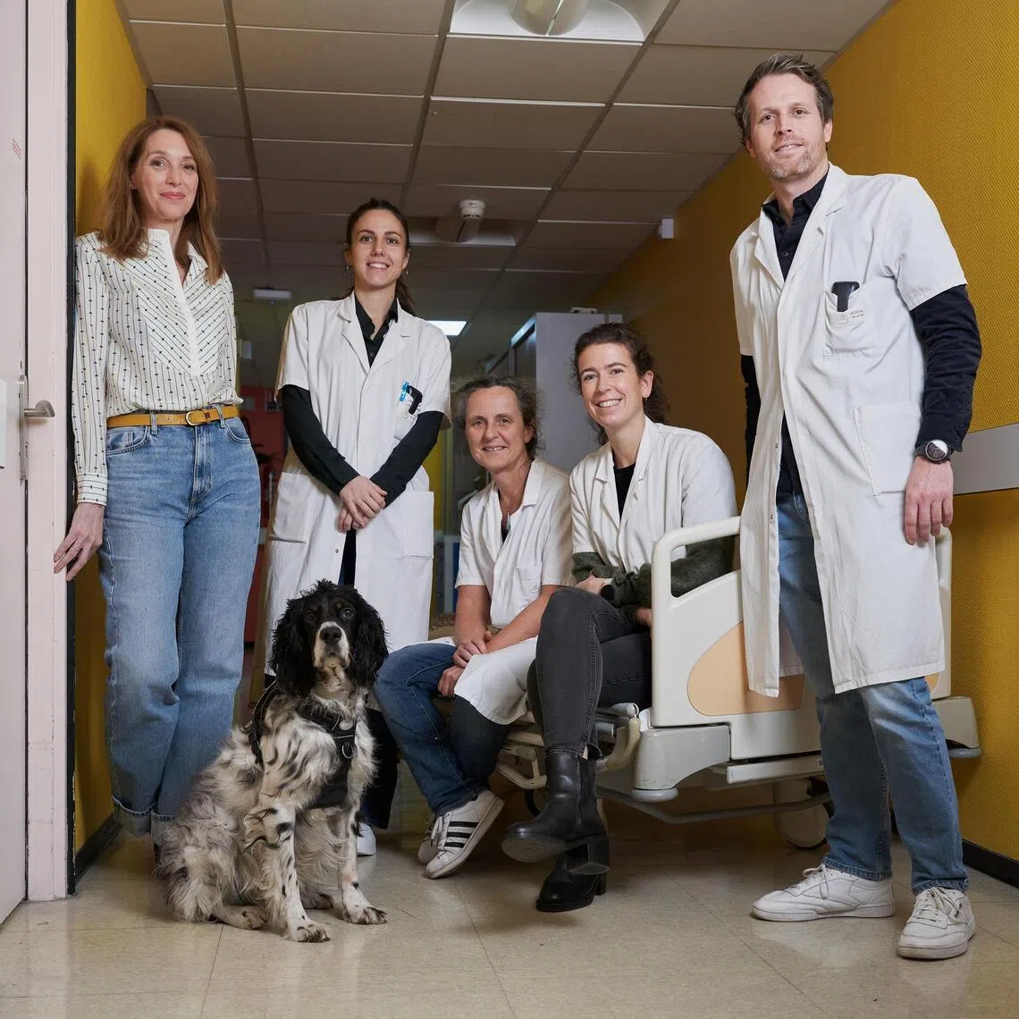 Sandra Kollender, left, the author of ÒSnoopy, un Chien Qui Fait du Bien,Ó with members of the medical team at the Institut Curie Hospital where Snoopy, a therapy dog, provides comfort, in Paris, Dec. 11, 2025. ÒWe need a gentle, joyful presence. A dog gives us that,Ó said Kollender. (Violette Franchi/The New York Times)