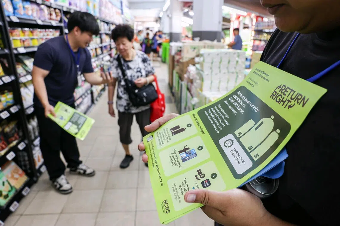 Ambassadors of the programme distributing flyers at the Sheng Siong supermarket in Ang Mo Kio as part of a six-month-long islandwide roadshow to inform residents about the recycling scheme.