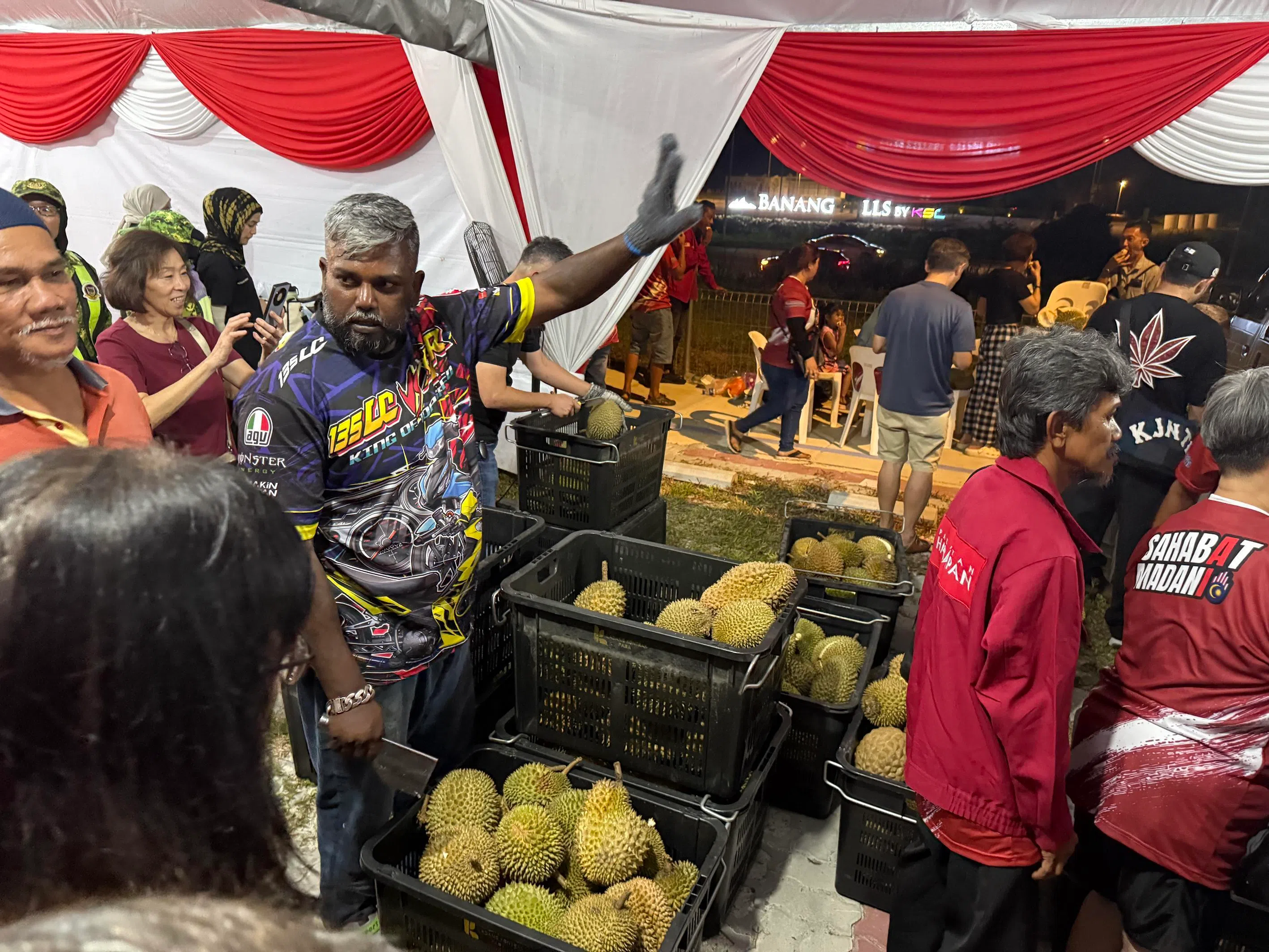 Rally-goers at a Pakatan Harapan event in Johor queue for free durians on July 9.