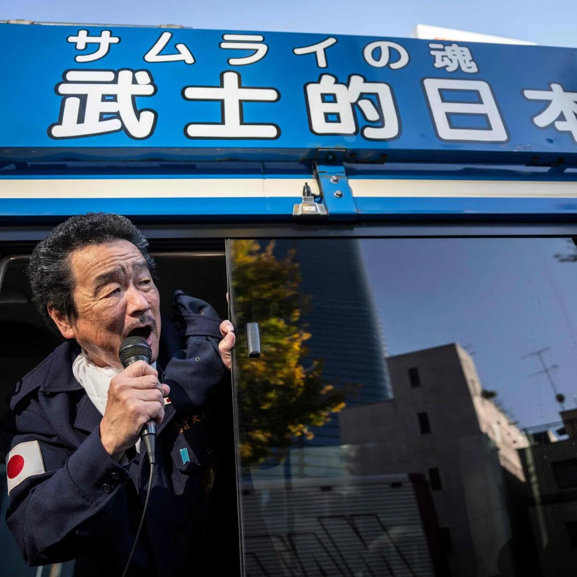 A member of the ultra-nationalist group Taikosha shouts slogans out of a van during a rally in Tokyo. 